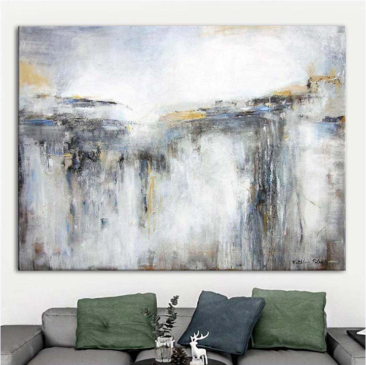 Abstract painting on a wall above a sofa with decorative pillows.